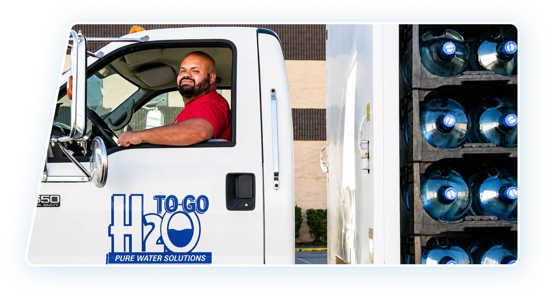H2O to Go team member carrying a purified water jug by the truck